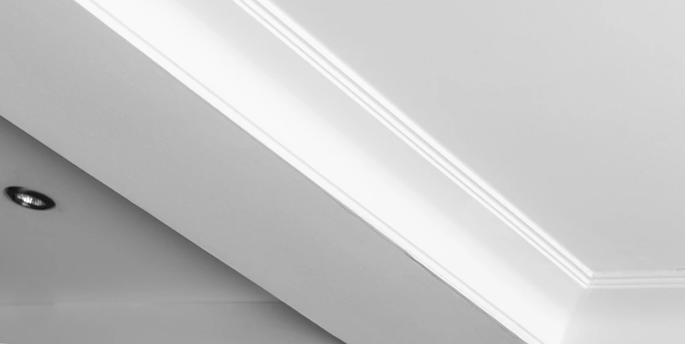 Plafond suspendu et à grilles avec lampes spots LED et construction de cloison sèche dans une pièce vide à l'intérieur de la maison