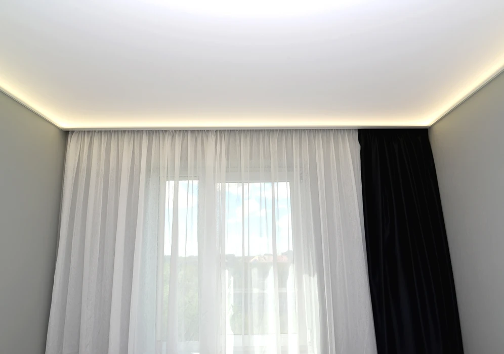 L'éclairage par LED caché d'un plafond étiré dans le salon
