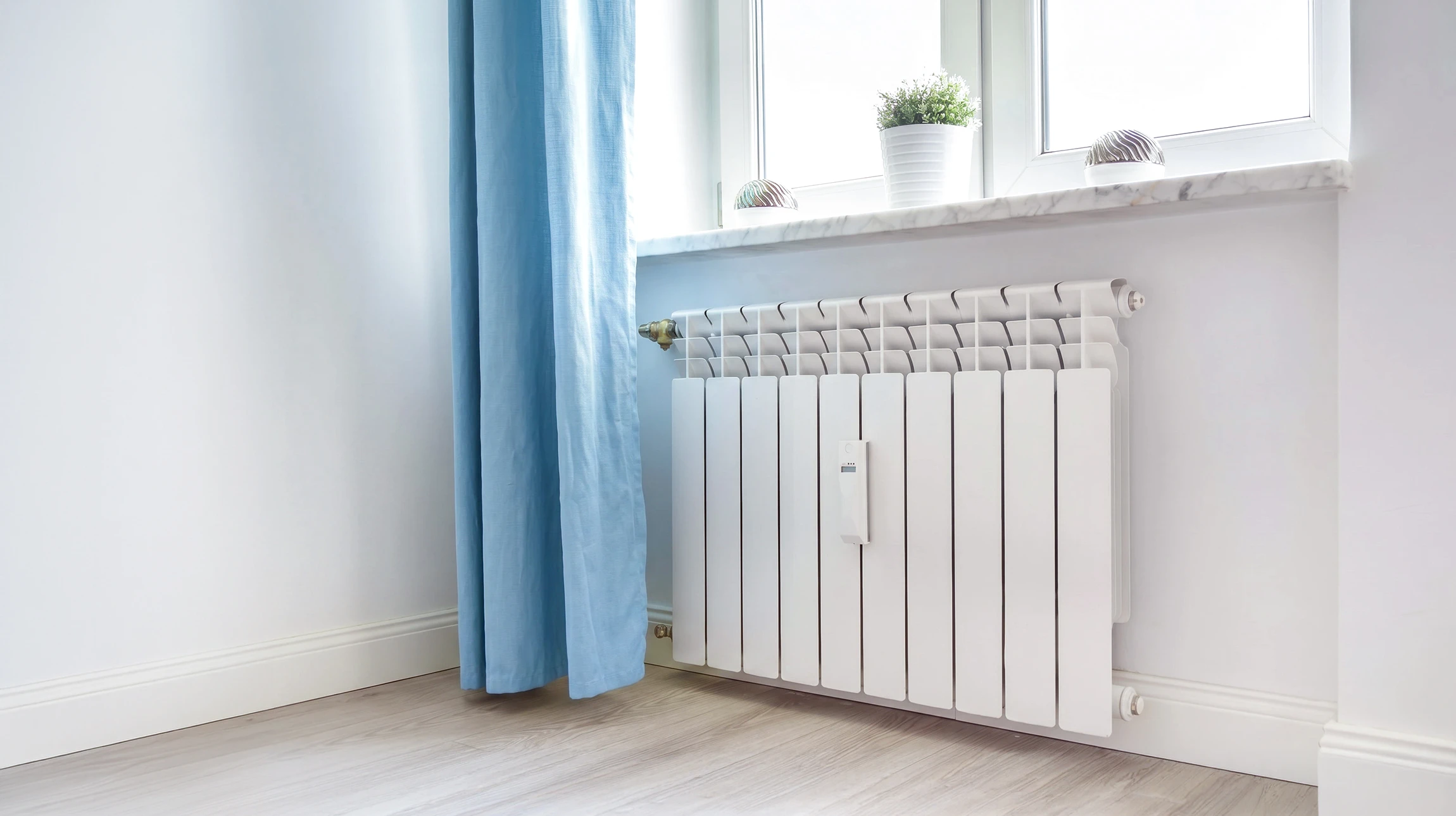Ouvrier en tenue rouge appliquant une chape liquide sur un plancher chauffant à l'intérieur d'un bâtiment en construction